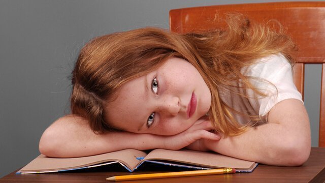 Girl lays her head down on a desk