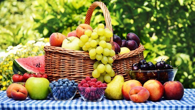Basket of fresh fruits in a garden