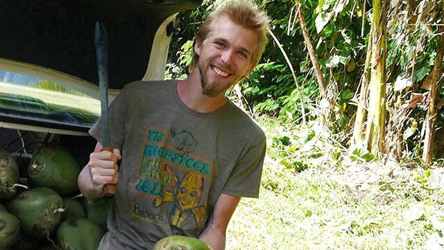 Jason Kvestad is about to chop open a coconut using a machete