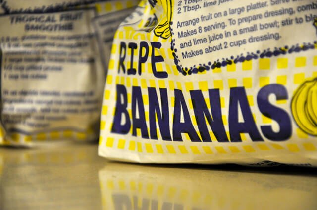 The words "ripe bananas" printed on a bag of bananas