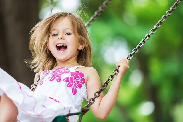 Young girl having fun on a swing set