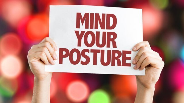 Sign says "Mind Your Posture" on background of lights