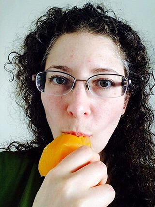 Rebecca Rosenberg eats a piece of fruit