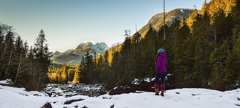 Tarah Millen stands on a snowy trail overlooking mountains