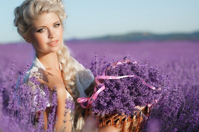 A blonde woman is photographed in a lavender field