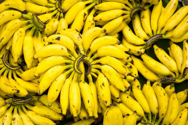 Many hands of bananas are stacked upon one another